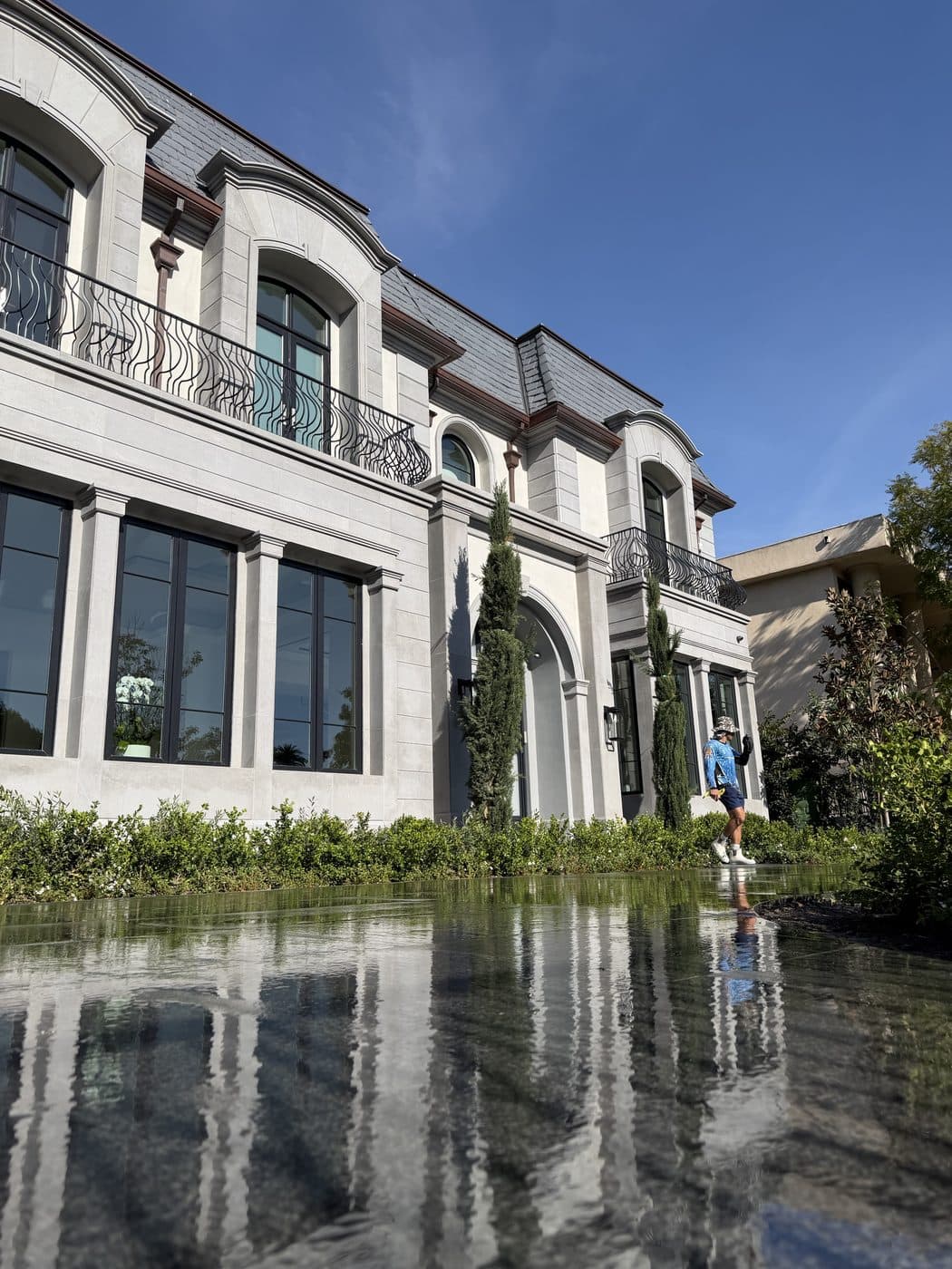 A Window Wizards tech at a grand stone estate with freshly cleaned windows in Los Angeles